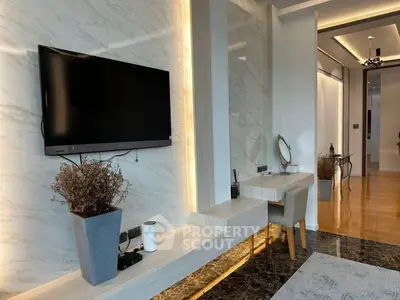 Modern living room with marble accents and wall-mounted TV, featuring stylish decor and sleek furniture.
