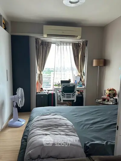 Cozy bedroom with modern decor and large window offering natural light and scenic view.