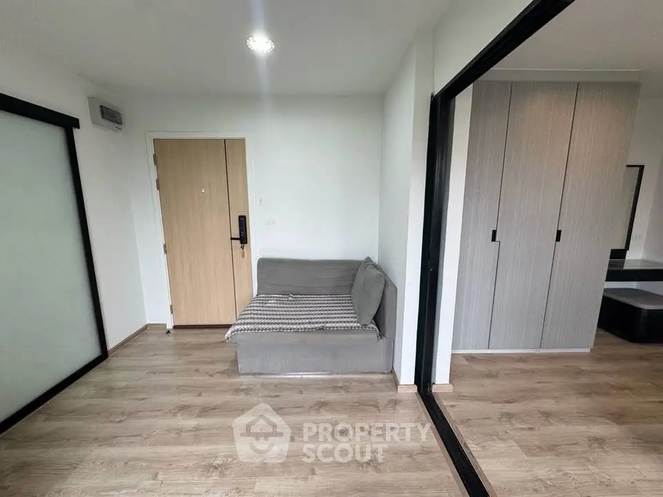 Modern apartment interior with wooden flooring and sleek sliding doors.