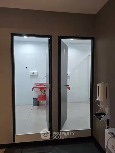 Modern public restroom with sleek design and sanitary fixtures, featuring dual stalls and contemporary amenities.
