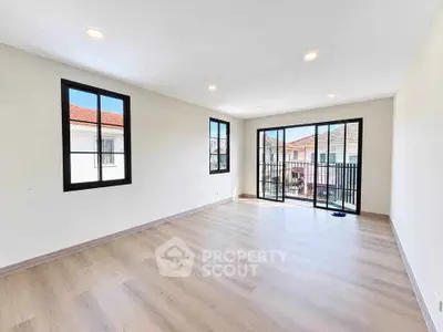 Spacious living room with large windows and balcony access in modern home