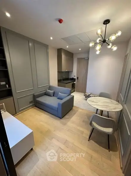 Modern living room with stylish lighting and compact furniture in a cozy apartment.