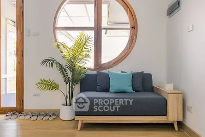 Stylish living room with modern sofa and circular window, perfect for relaxation.