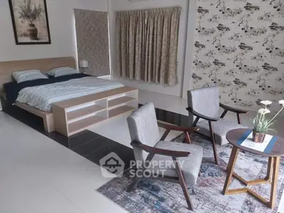 Spacious bedroom with modern decor and cozy seating area