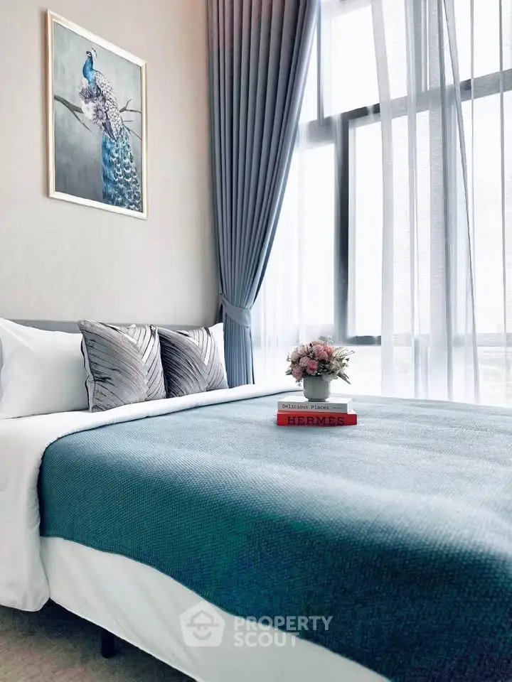 Elegant bedroom with modern decor, featuring a stylish bed, large window, and chic artwork, perfect for relaxation.