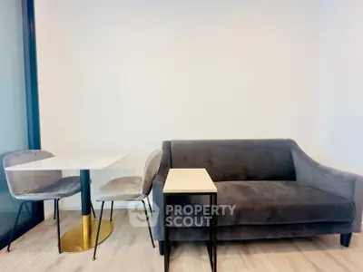 Modern living room with sleek gray sofa and stylish dining set