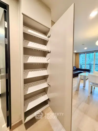 Modern apartment interior with open storage cabinet and stylish living room view.