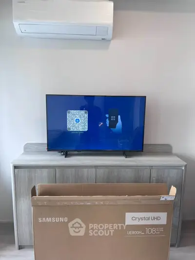 Modern living room with Samsung Crystal UHD TV and air conditioning unit.