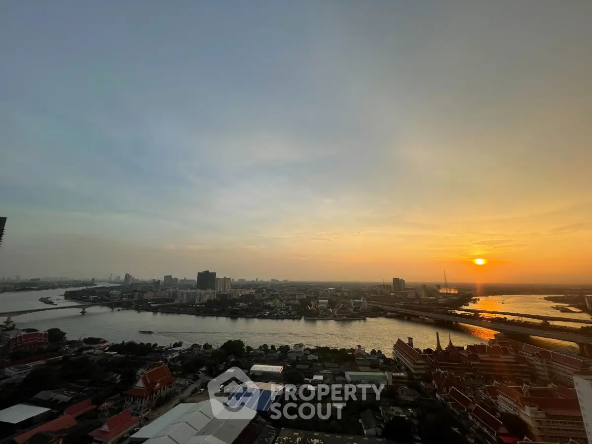 Stunning sunset view over a cityscape with river, perfect for high-rise living.