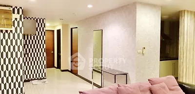 Modern living room with stylish decor and open layout, featuring geometric wall patterns and sleek furniture.