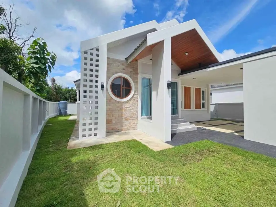 Modern single-story house with unique circular window and spacious lawn