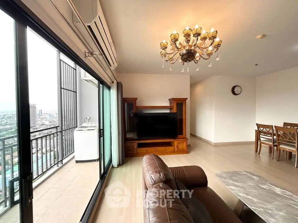 Spacious living room with elegant chandelier and balcony view in modern apartment