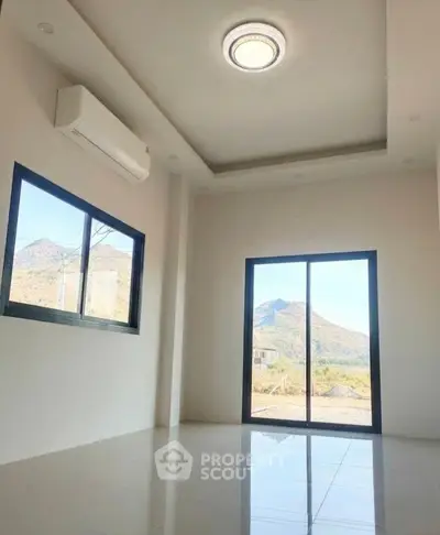 Bright room with mountain view, large windows, and modern ceiling light in a minimalist design.