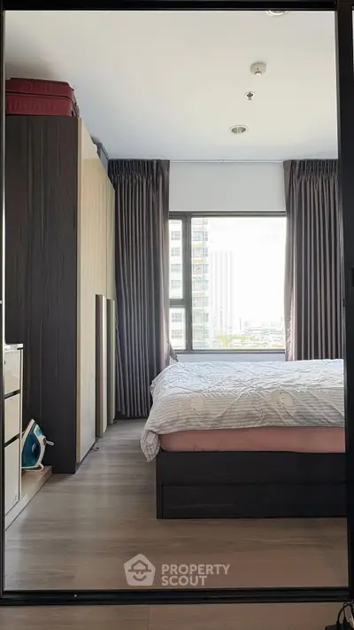 Modern bedroom with large window and stylish decor in urban apartment