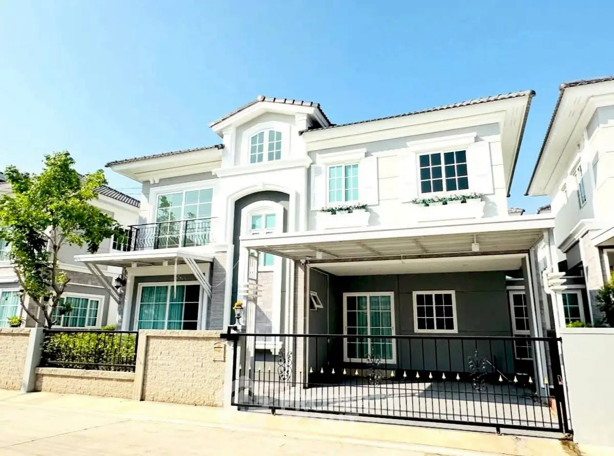 Elegant two-story house with modern design and spacious driveway in a sunny neighborhood.