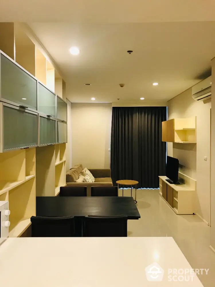 Modern living room with stylish furniture and built-in shelving in a cozy apartment.