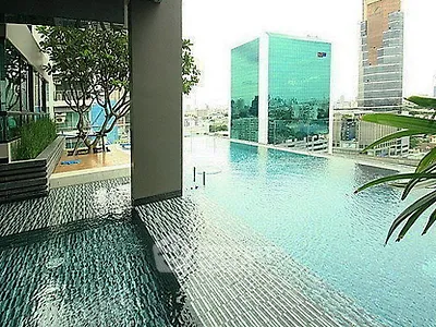 Luxurious rooftop infinity pool with stunning cityscape views in modern high-rise building.