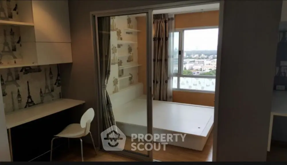Modern apartment with study area and bedroom featuring large windows and city view.