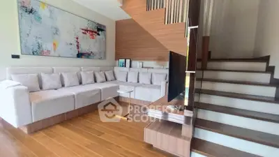 Modern living room with stylish staircase and cozy sectional sofa