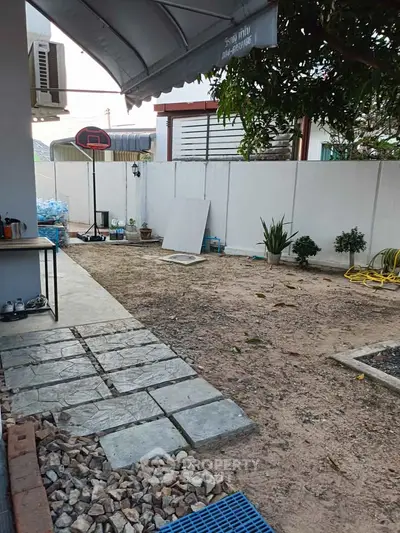 Spacious backyard with potential for landscaping, featuring a basketball hoop and patio area.