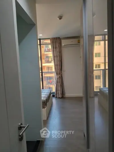 Modern bedroom with balcony view and air conditioning in urban apartment