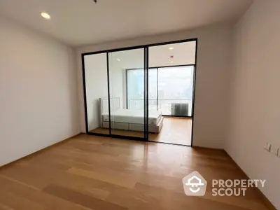 Spacious and bright corner unit with large windows and a seamless transition to a private balcony offering an urban view, perfect for modern living.