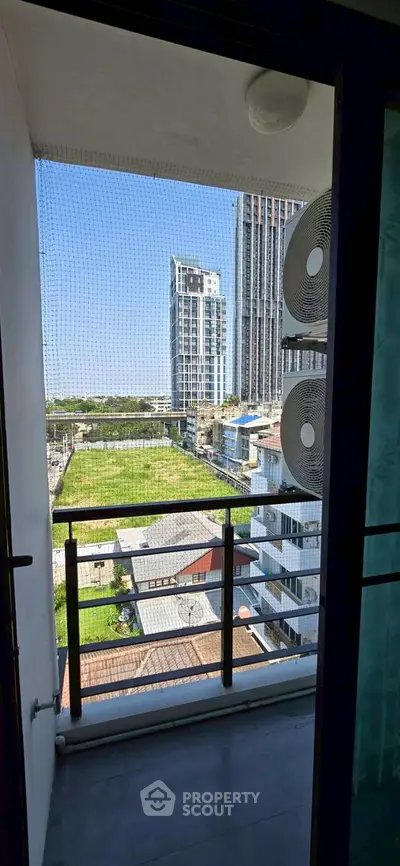 Stunning balcony view with modern cityscape and lush greenery, perfect for urban living.