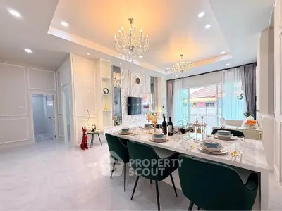Luxurious open-plan living and dining area with elegant chandeliers and modern decor.