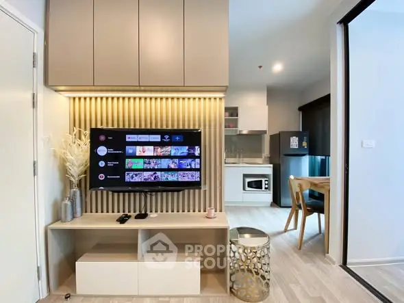 Modern living room with wall-mounted TV and stylish decor in open-plan apartment