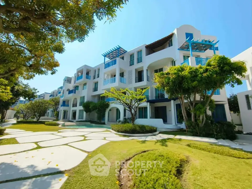 Stunning modern apartment building with lush landscaping and unique architectural design.