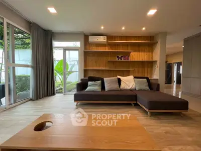 Spacious living room with modern sofa and garden view, perfect for relaxation.