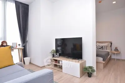 Modern living room with stylish decor and open view into cozy bedroom