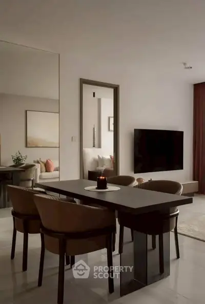 Modern dining area with sleek table and chairs, large mirror, and wall-mounted TV in stylish apartment.