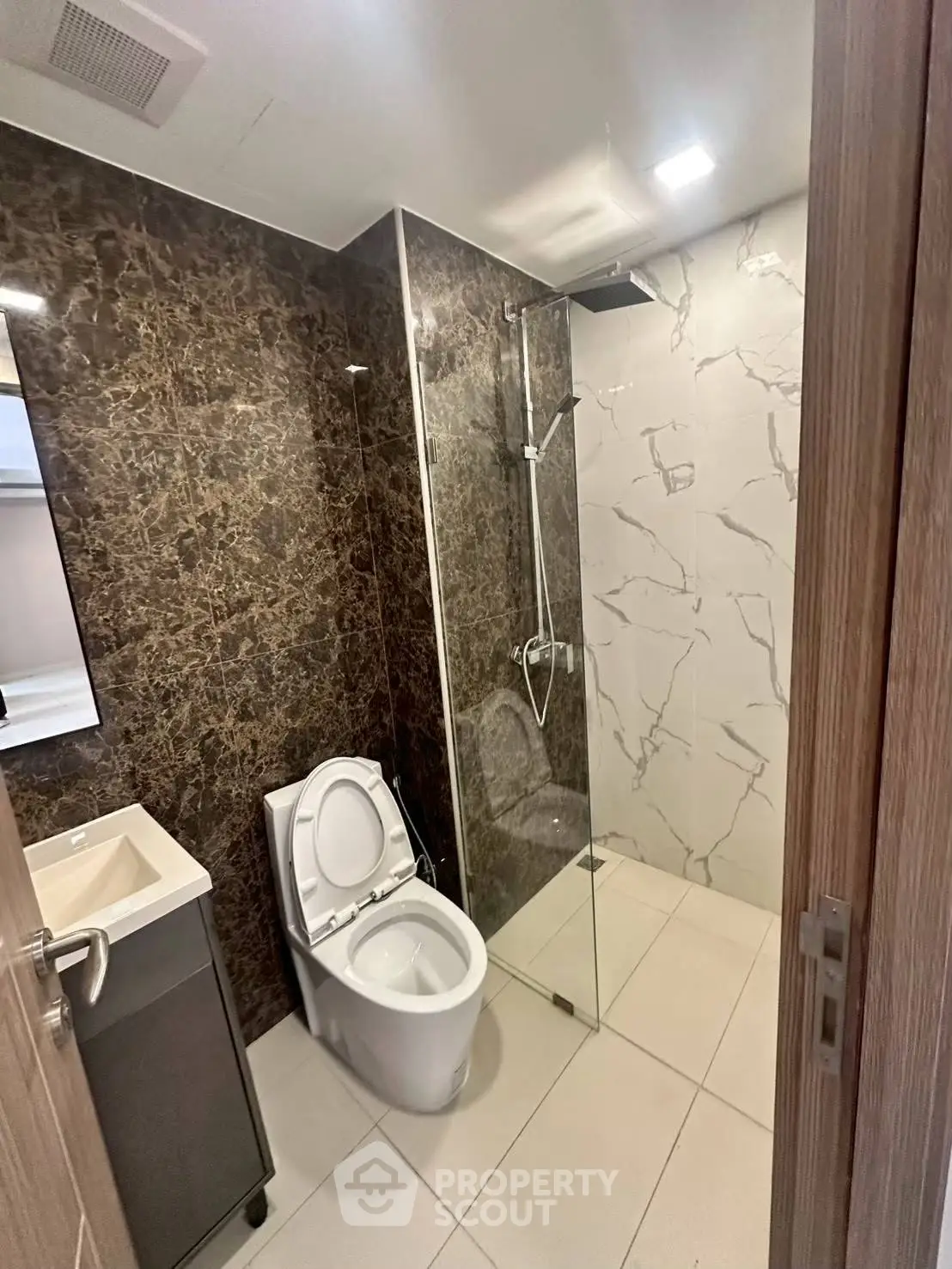 Modern bathroom with glass shower and marble accents