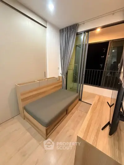 Modern bedroom with balcony access and sleek wooden furniture