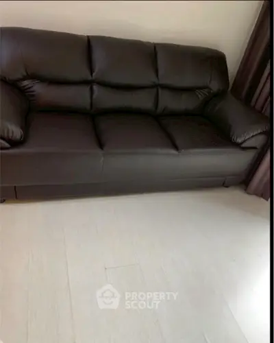 Luxurious black leather sofa in a modern living room setting.