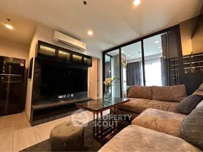 Modern living room with plush sofa and large TV, featuring sleek design and ambient lighting.