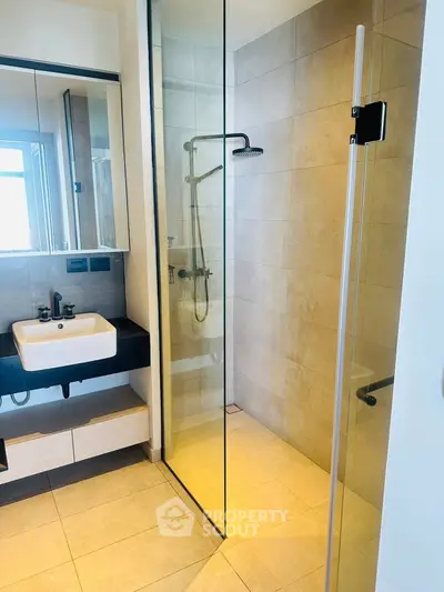 Modern bathroom with glass shower and sleek fixtures in a contemporary home.