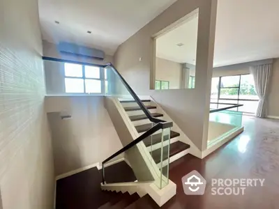 Spacious multi-level living area with modern staircase, gleaming floors, and abundant natural light, perfect for upscale urban living.