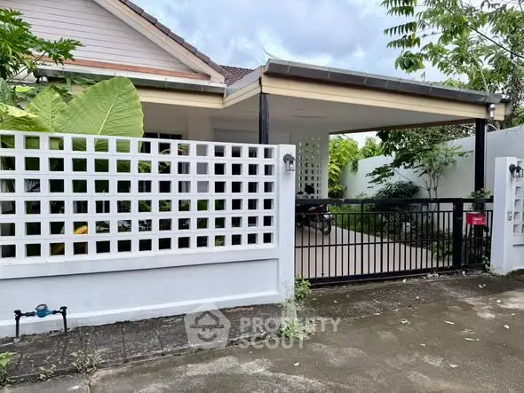 Charming single-story home with gated entrance and lush greenery