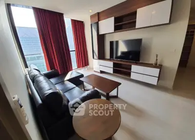 Modern living room with sleek furniture and large windows in a high-rise apartment.