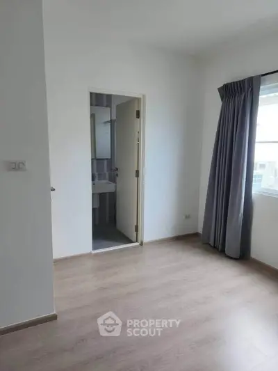 Spacious bedroom with ensuite bathroom and large window for natural light.