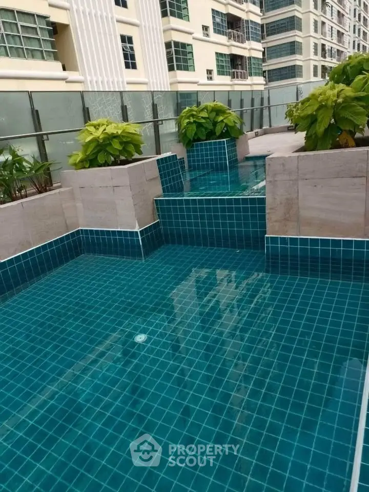 Luxurious rooftop pool with modern design and lush greenery in a high-rise building.