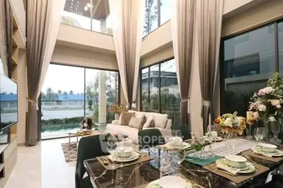 Luxurious double-height living room with elegant decor and large windows offering stunning views.