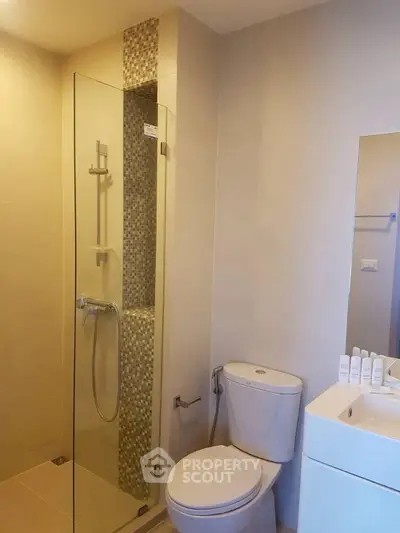 Modern bathroom with glass shower and sleek fixtures in a contemporary apartment.