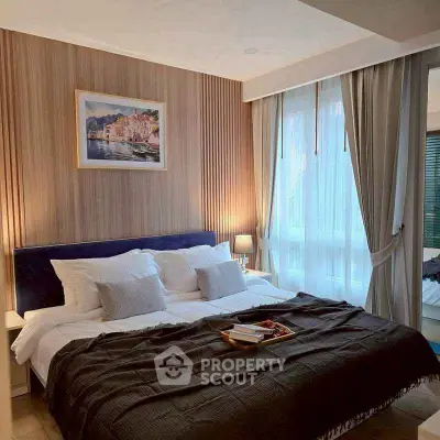Luxurious bedroom with elegant decor and large window for natural light.