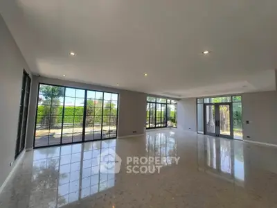 Spacious modern living room with large windows and garden view, perfect for natural light lovers.