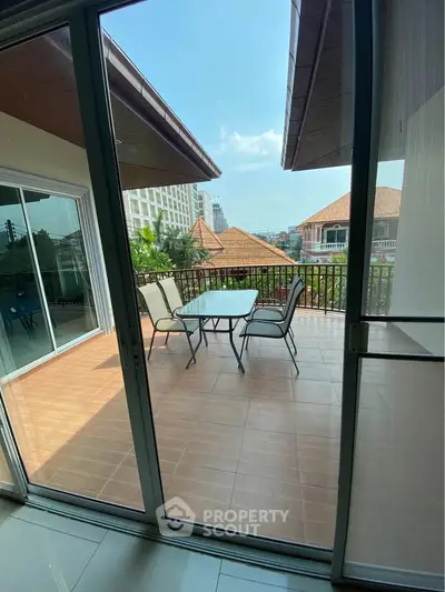 Spacious balcony with outdoor seating and scenic view, perfect for relaxation and entertainment.