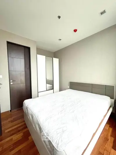 Modern bedroom with sleek design and wooden flooring in a contemporary apartment.