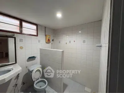 Spacious bathroom with modern fixtures and tiled walls